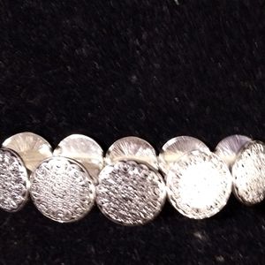 Ladies silver tone stretching bracelet. Round stamped pieces